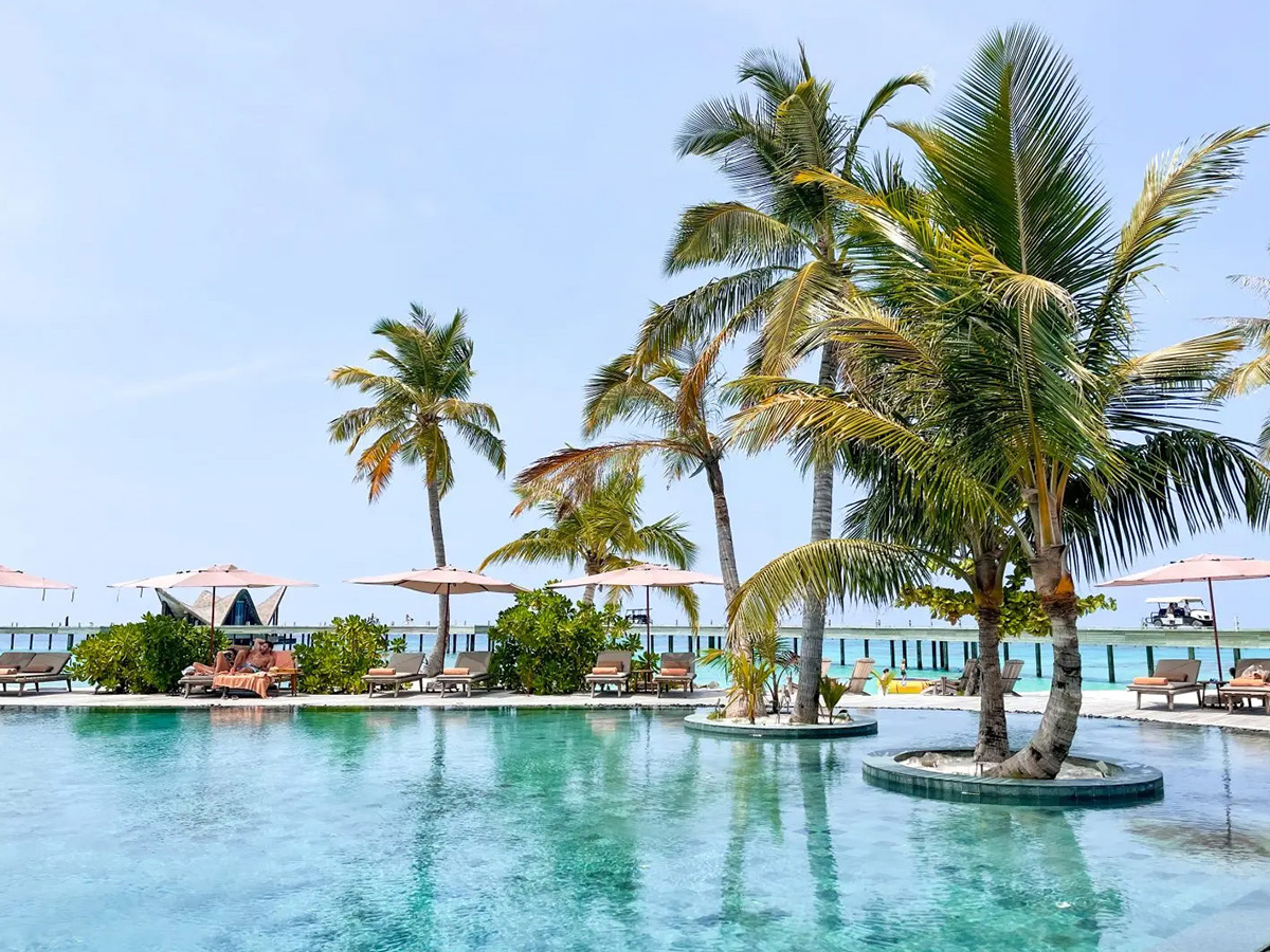 Piscina principal y playa de arena blanca en JOALI Maldives