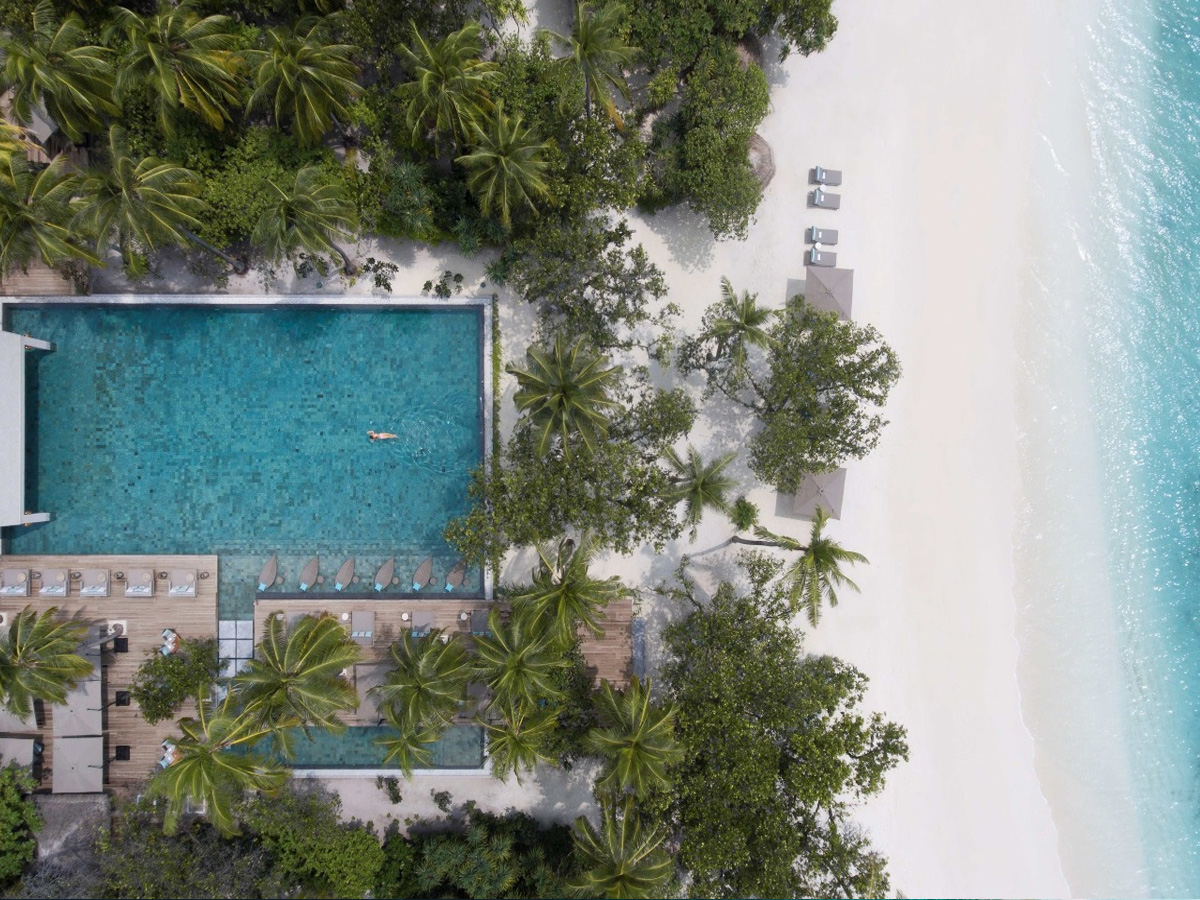 Piscina principal y playa de arena blanca en Vakkaru Maldives