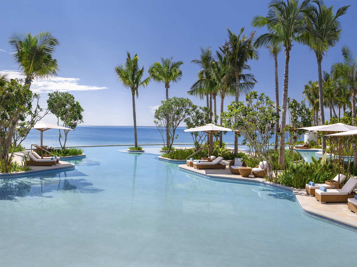 Piscina principal y playa de arena blanca en Waldorf Astoria Maldives Ithaafushi